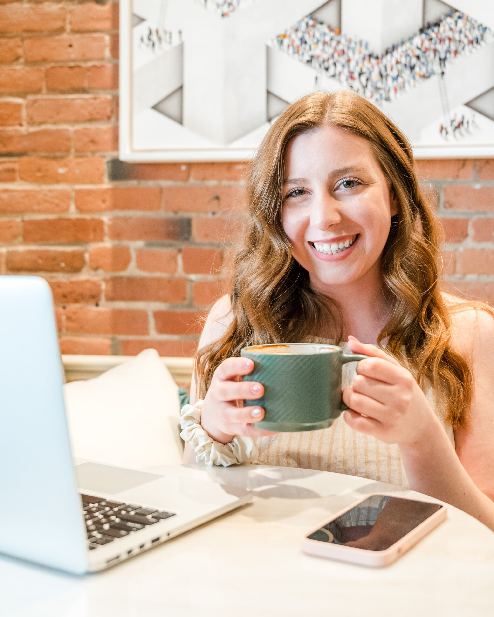 Montreal social media strategist holding a coffee while planning a content calendar on her computer